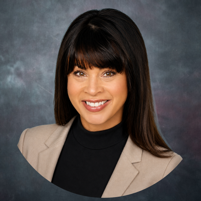 Head-and-shoulders portrait of a smiling woman with dark hair in a beige blazer and black top.